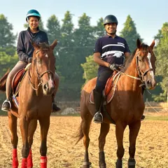 A couple enjoys a riding lesson together in our arena. Learning to ride is a fantastic activity for partners and friends to share, building confidence and creating lasting memories.