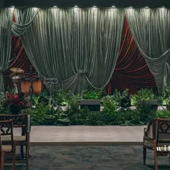 A stage set for a sangeet inspired by the dramatic artistry of Raja Ravi Varma. We used deep, contrasting velvets and lush foliage instead of extensive florals to create a moody, theatrical ambiance that feels like stepping into a timeless painting.