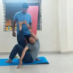 Hands-on adjustments are a key part of my teaching. Here, I am helping a student find the correct alignment in a seated twist. This personal guidance ensures you practice safely, understand the posture deeply, and get the most out of every movement.