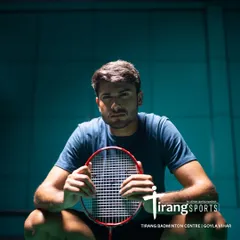 A player takes a moment to focus between rallies. The professional lighting and well-maintained courts at our Goyla Vihar center provide the perfect environment for serious training.