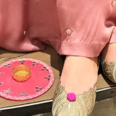 The perfect finishing touch. These gold woven juttis with a playful pink pom-pom add a pop of color and fun to this festive look.