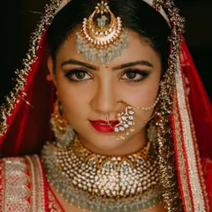 For the classic bride who dreams of a grand entrance, a bold red lip and defined eyes are timeless. This close-up shows how I balance a strong lip with radiant skin and shimmering gold eyeshadow for a truly regal North Indian bridal look.
