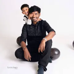 A fun and playful moment between a father and his son during a third birthday shoot. The son's happy expression is priceless.