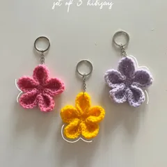 A set of three hibiscus flower keychains, shown here in bright pink, sunny yellow, and soft lavender. These are perfect for adding a pop of tropical color.
