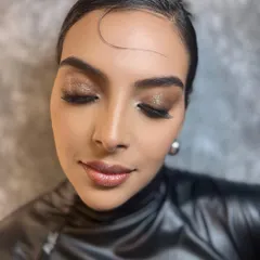 A glamorous look with shimmery eyelids and a nude brown lip gloss. This close-up shows the detail of the sparkle and the glossy finish, perfect for an editorial feature.