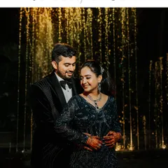 An elegant reception portrait. The couple stands before a glittering fountain, their formal attire and the romantic lighting creating a timeless and sophisticated image.