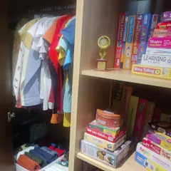 This child's wardrobe combines hanging space for shirts with shelves for games and puzzles. Keeping their favorite activities visible and accessible encourages both play and tidiness.