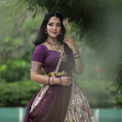 This shot showcases a unique printed lehenga with a rich purple blouse. The outdoor setting and the model's graceful pose highlight the traditional yet contemporary feel of the outfit.