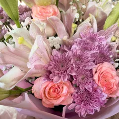 A stunning close up of a fresh bouquet featuring pink lilies, roses, and other beautiful blooms. Fresh flowers can say it all without you having to say a word.