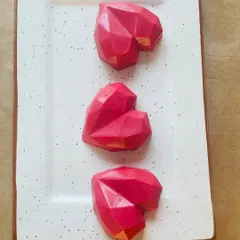 Our mini geometric heart-shaped cakes are a perfect small bite. These are filled with rich chocolate cake and covered in a colored chocolate shell.