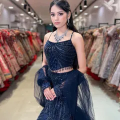This navy blue fish-cut lehenga is a modern and glamorous choice for a reception or cocktail party. The sequin work and spaghetti-strap top create a chic, contemporary silhouette.