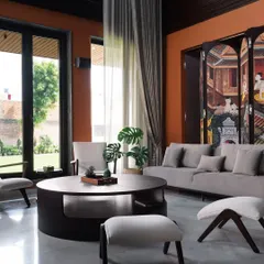 Natural light was key in this space. The large windows and sheer curtains soften the formal setting, connecting the rich interiors with the green garden outside and creating a serene, airy atmosphere during the day.
