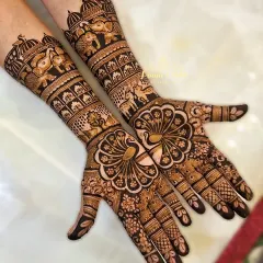 A design fit for the queen of the family. For the groom's mother, we created this regal, full-coverage henna featuring majestic peacocks on the palms and intricate bands of elephants and architectural patterns on the forearms.