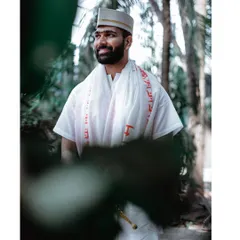 A candid portrait of the groom looking away with a smile during his Haldi ceremony.