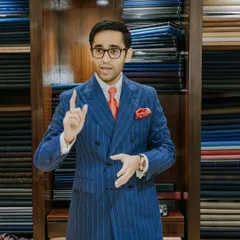 A portrait of sartorial excellence. Our director, dressed in a bespoke double-breasted pinstripe suit, engages with guests during our exclusive event with Scabal, showcasing the sharp tailoring that defines our brand.