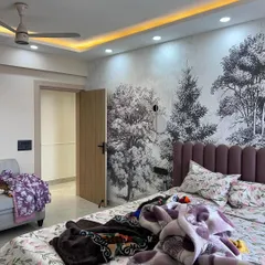 Another angle of the bedroom with the forest mural, showing the false ceiling with cove lighting that enhances the room's atmosphere.