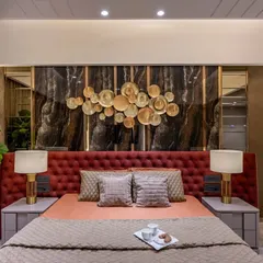 We designed this master bedroom to be a statement of bold elegance. A floor-to-ceiling upholstered headboard in rich crimson is set against a dark marble panel with a bespoke metallic art installation, creating a dramatic and luxurious focal point.