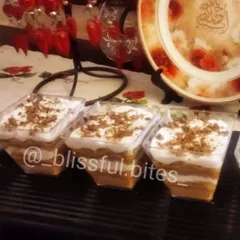 Here is my bestselling Banoffee Pie, served in convenient individual cups. They feature a crunchy biscuit base, a rich layer of toffee, fresh bananas, and a generous topping of cream and chocolate shavings.