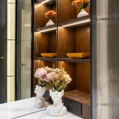 A perfect balance of luxe and simplicity, this dressing area features warm wooden shelves paired with profile shutters in fluted glass. The muted tones create a serene backdrop, while the fine detailing in materials adds quiet sophistication.
