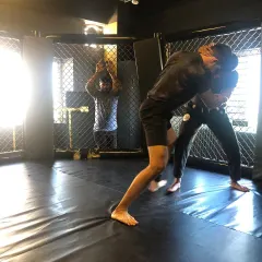 We use the cage to simulate real MMA scenarios. This shot from our BJJ Jam shows two members working on their wrestling and clinch game against the fence.