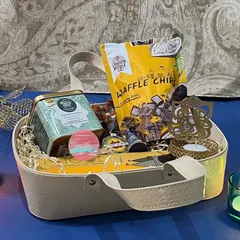 Who doesn't love gourmet snacks? This Diwali hamper is a basket full of love, featuring a crocodile-patterned basket, Phool incense sticks, plantable crackers, Isvaari tea, and a Ganesha shadow T-light holder.