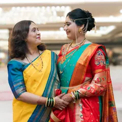 A loving look between a bride and her mother, both dressed in beautiful traditional sarees.
