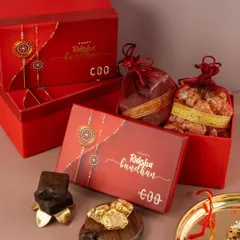 This photo captures a luxurious Raksha Bandhan gift set. We used rich red packaging and warm lighting to evoke a festive and traditional mood, highlighting the premium quality of the sweets inside.