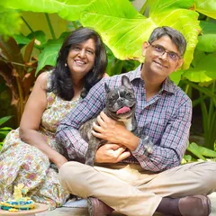 A beautiful family portrait celebrating their Frenchie's birthday. The colorful background and happy smiles make this a perfect celebratory shot.