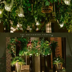 An enchanted forest Sangeet at the St. Regis Mumbai. The ceiling was covered in lush greenery, hanging florals, and whimsical elements like glass birds, creating a magical atmosphere for a night of dancing.