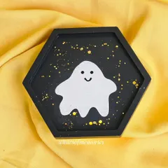 This hexagonal trinket tray features a sparkly ghost against a black background with gold flecks. It's a practical way to keep small items organized while being festive.
