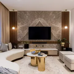 This living room is designed for connection and comfort. We combined a gracefully curved sofa with plush ottomans and striking gold coffee tables to create a space that is both inviting and sophisticated. The book-matched marble TV wall serves as a stunning focal point, demonstrating our commitment to using premium materials with artistic precision.