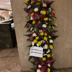 For moments that require a grand statement, I design impressive standing floral arrangements like this 6-foot tall piece. It was created for a corporate event to welcome guests with a vibrant mix of chrysanthemums, roses, and fresh ferns.