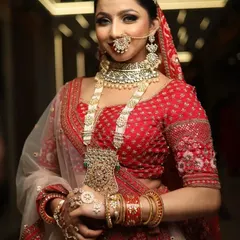 A classic bridal portrait. This look features a soft, glowing base, a defined eye with a subtle wing, and a bold red lip, complemented by traditional jewellery for a timeless appeal.