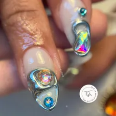 A close-up of the abstract 3D silver chrome design, showing how the iridescent jewels are nestled within the metallic structure.