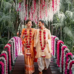 A quiet walk across a bridge adorned with flowers at a beautiful Maharashtrian wedding in Thane. This image captures the grace and connection of the couple, showcasing the timeless elegance of traditional ceremonies.