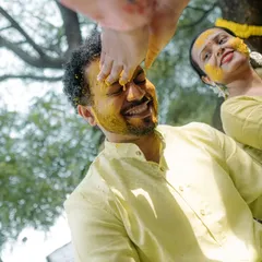 A playful moment during the Haldi ceremony. The bride's sister applies turmeric with her foot, a fun tradition that results in genuine laughter and great candid shots.
