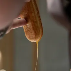 Filling a freshly baked éclair shell. The key is a light choux pastry and a delicious, stable cream filling, both of which you'll master in our classes.