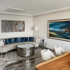 This director's cabin in the Stainless Steel Office features a striking hammered-metal coffee table and a curved sofa. The design reflects the user's ethos, with a focus on unique materials and art, including a Subodh Gupta sculpture in the adjacent courtyard.