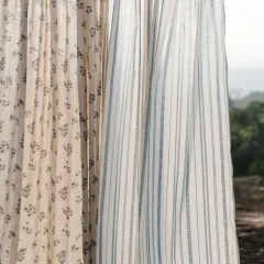 A close-up of our 'Pause' collection, showcasing the beautiful texture of our light-filtering sheers. Here, a floral pattern is paired with a misty blue stripe, both crafted from natural, breathable fabrics.