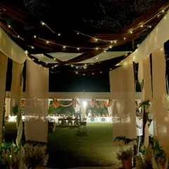 An enchanting walkway created with draped fabric and fairy lights, leading guests into the main celebration area for the 25th anniversary party.