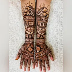 A beautiful and traditional baby shower mehendi. This design incorporates auspicious elements like temple bells, baby footprints in a lotus, and a baby in a cradle, all framed by classic floral and checkerboard patterns.