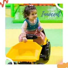 The innocent smile. This little one is enjoying a ride on the mini-tractor, completely lost in her own world of play.
