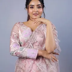 A beautiful portrait of our model in a baby pink saree from our 'Yuthika' collection. The ensemble features a velvet blouse with appliqué and cutdana work, and a pre-draped net saree that combines comfort with high fashion.