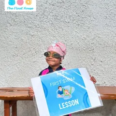 Another proud swimmer holding her 'First Swim Lesson' certificate. We love celebrating these first achievements with our students.