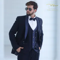 This custom-fit navy tuxedo is designed as a three-piece suit with a matching waistcoat. The detailed embroidery on the shoulder makes it a standout piece for any groom's reception or formal party.