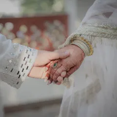 The simple act of holding hands tells a powerful story. This close-up focuses on the connection between Aditi and Ananth, highlighting the bride's henna and the groom's elegant attire.
