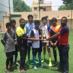 Our U-16 football champions with their coaches, holding the Stallion Football Cup trophy. We are proud to guide these talented young athletes.