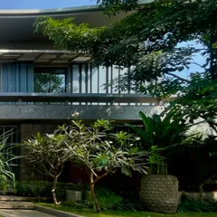 A view of 'STILL HOME' through the surrounding foliage. The architecture is designed to be an extension of the residents' way of life, expressing energy and emotion through form and material.