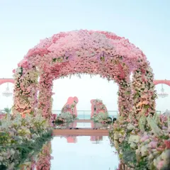 The 'Echoes of Pink' mandap was a breathtaking archway completely covered in thousands of pink and white flowers, signifying the blooming of a new relationship. The mirrored aisle reflected the sky and the floral splendor, creating a truly magical path for the bride.