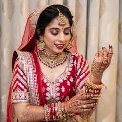 A stunning North Indian bridal look. The classic red lehenga is paired with dramatic eye makeup and a bold red lip.